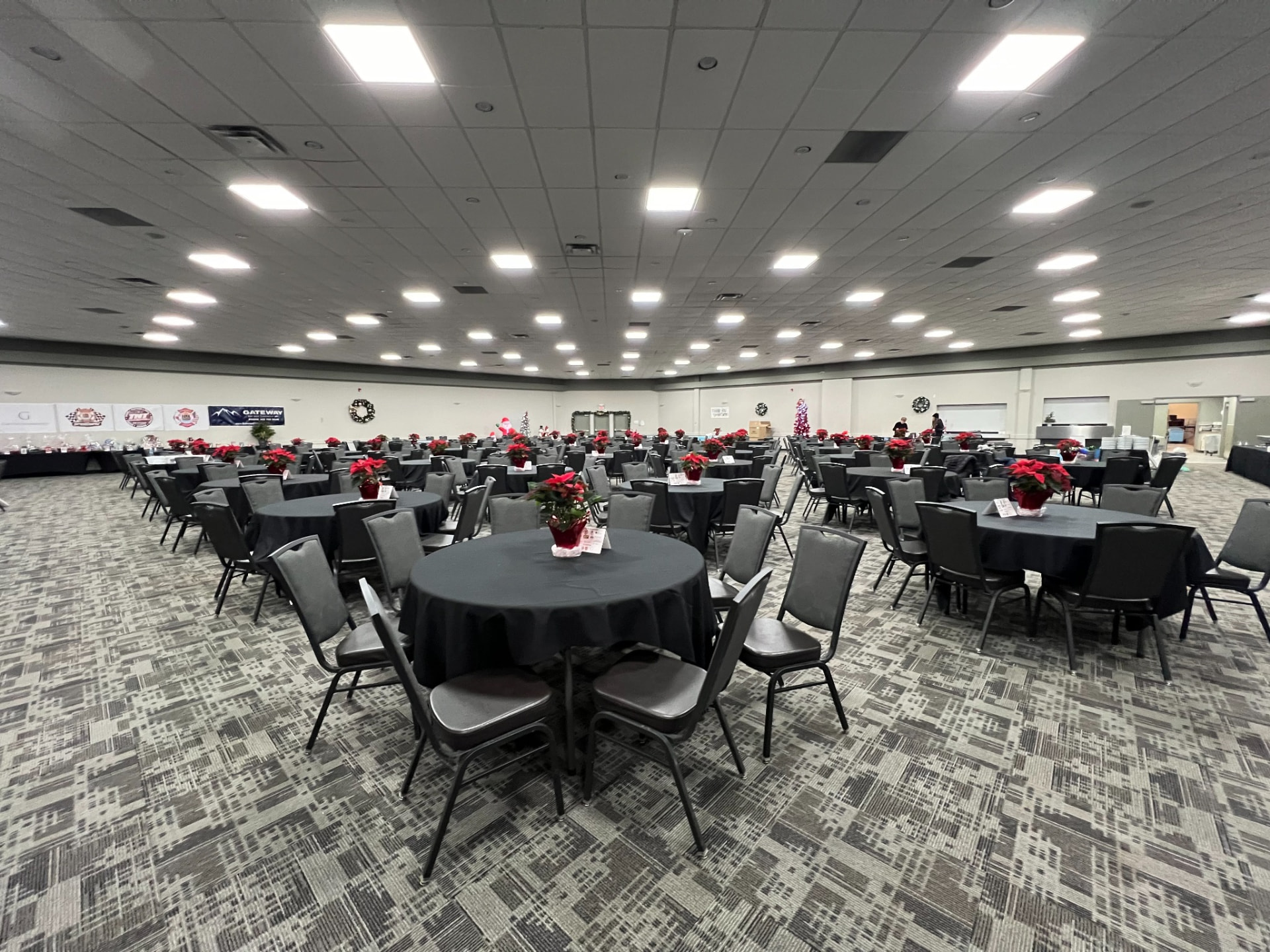 The banquet hall set with round tables and poinsettias before the breakfast