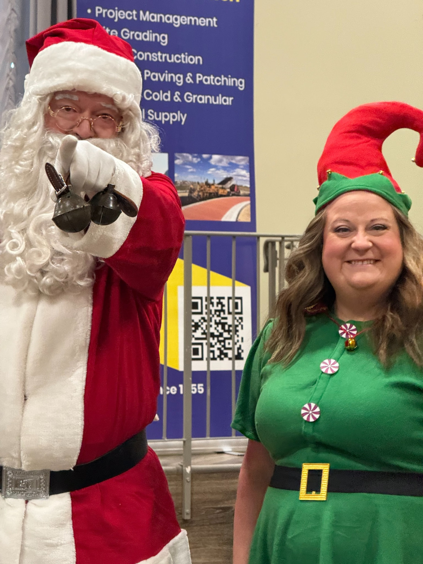 Santa and an elf volunteer greeting families at the Christmas Wish Breakfast